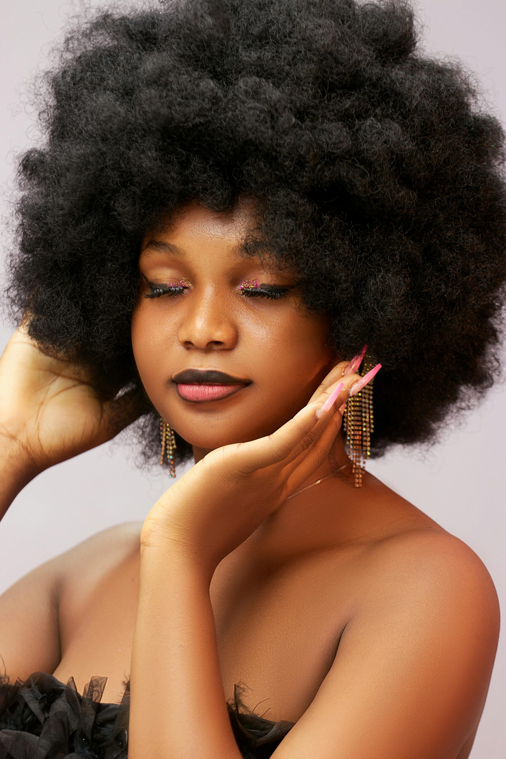 Home Studio portrait of a stylish woman with afro hair and glamorous makeup.