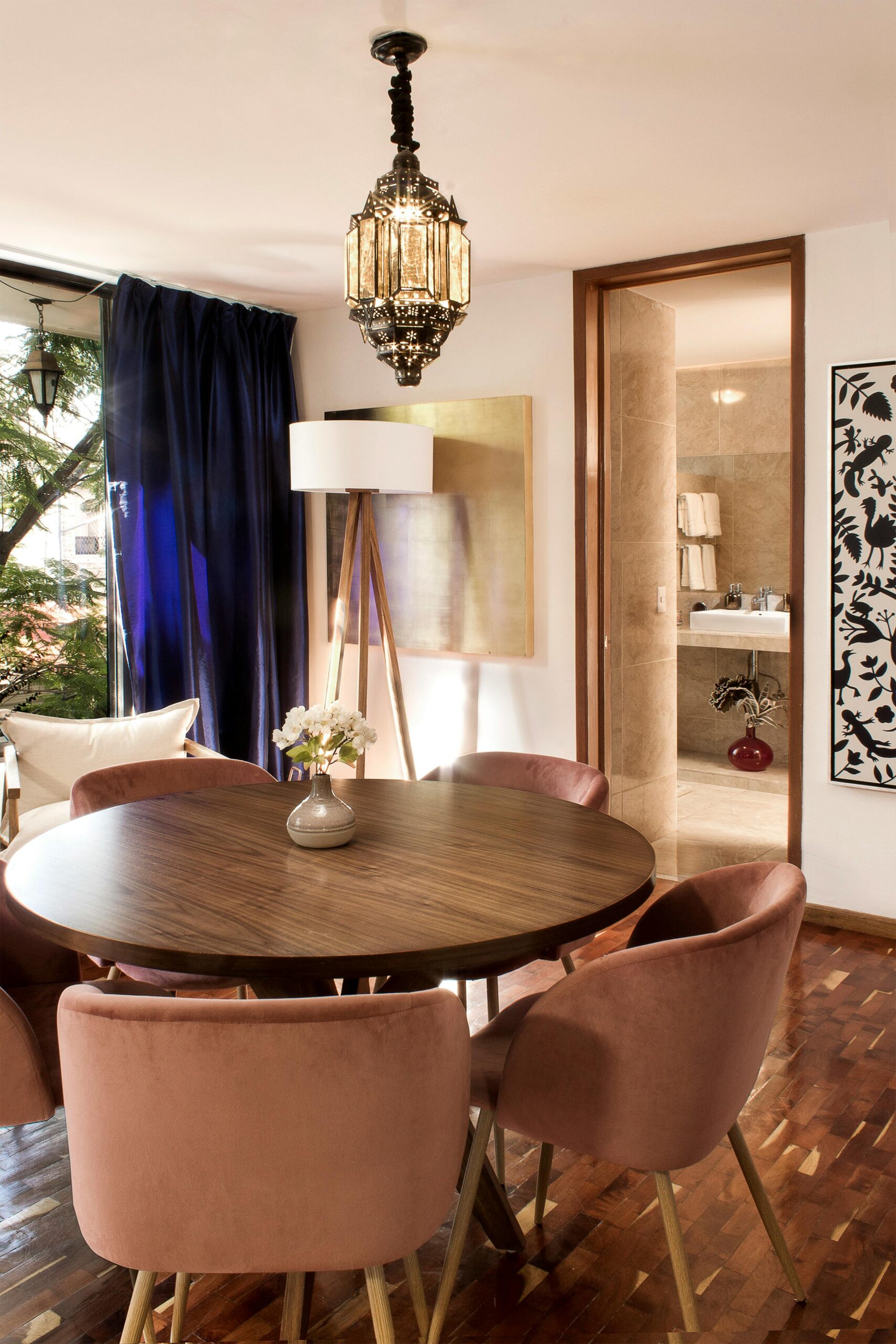 Stylish dining room with round table, plush chairs, and modern decor in Mexico City.